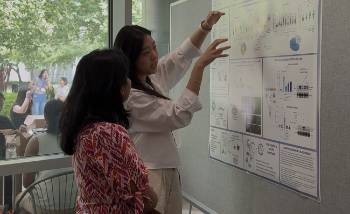 Genetics & Epigenetics student Heather Tsong and one of the judges standing by Heather's poster and talking about it.
