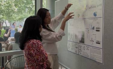 Genetics & Epigenetics student Heather Tsong and one of the judges standing by Heather's poster and talking about it.