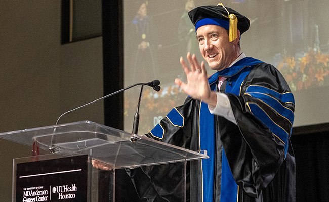Jones at podium addressing graduates at MD Anderson UTHealth Houston Graduate School of Biomedical Sciences 2025 commencement.