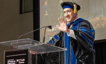 Jones at podium addressing graduates at MD Anderson UTHealth Houston Graduate School of Biomedical Sciences 2025 commencement.