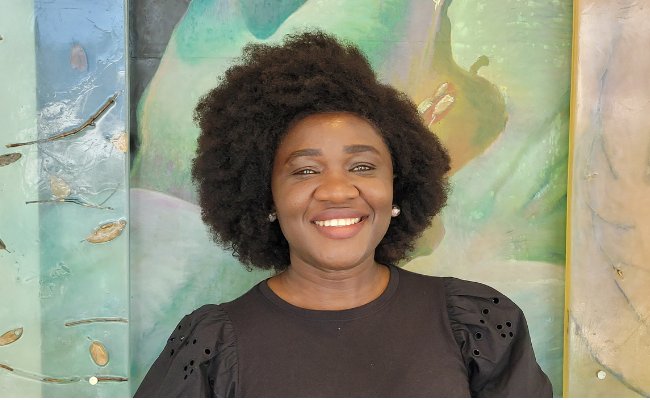 Smiling woman in front of a multicolored bacground