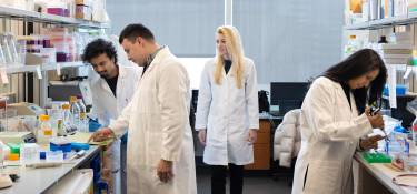 Kendra Carmon, PhD, and 3 students working in a lab