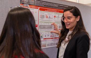 Student explaining her scientific poster at the Graduate School's 2023 Graduate Student Research Day.