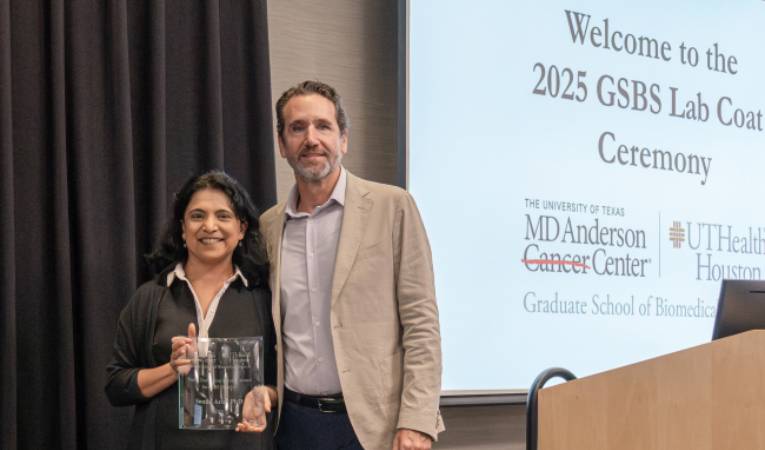 Arur standing with Dean Alejandro Aballay aafter receiving award at October's Lab Coat Ceremony.