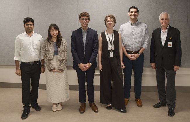 Hwang standing with peers receiving 2025 Dean's Research Award.