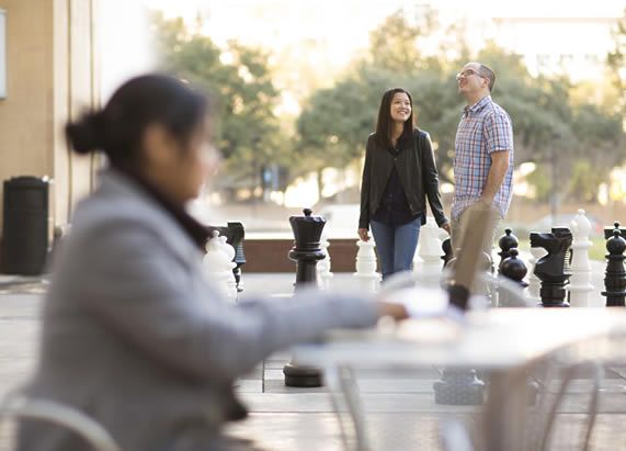 Students walking by a giant chess set photo