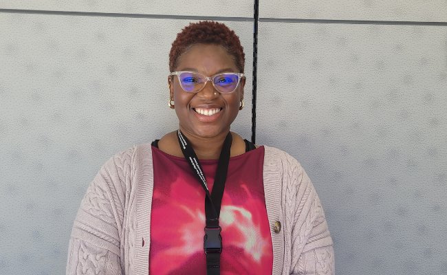 smiling woman in glasses and a pink shirt