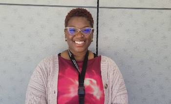 smiling woman in glasses and a pink shirt