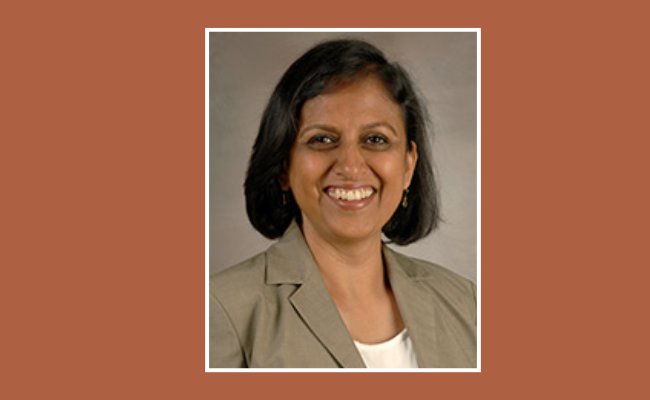 smiling woman on an orange background with a white border