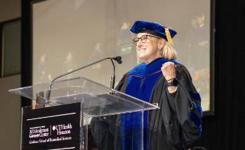 Bray addressing students at the podium at 2025 commencement.