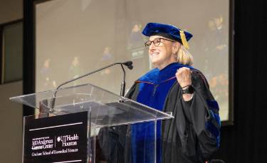 Bray addressing students at the podium at 2025 commencement.
