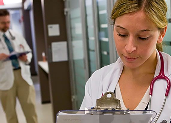 A doctor reviews papers on a clipboard photo