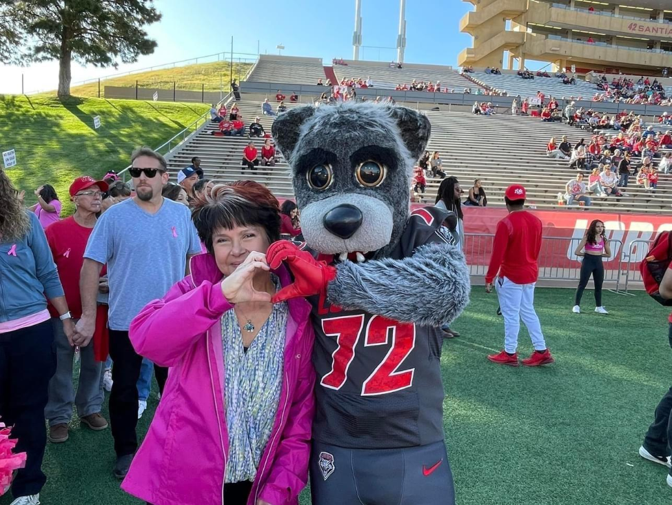 Sanchez making heart hands with University of New Mexico’s Lobo Louie.